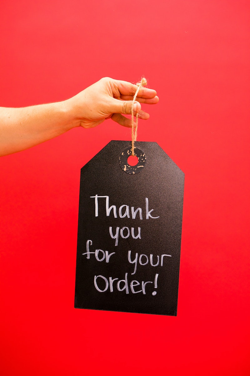 A Person Holding a Thank You For Your Order Hanging Signage