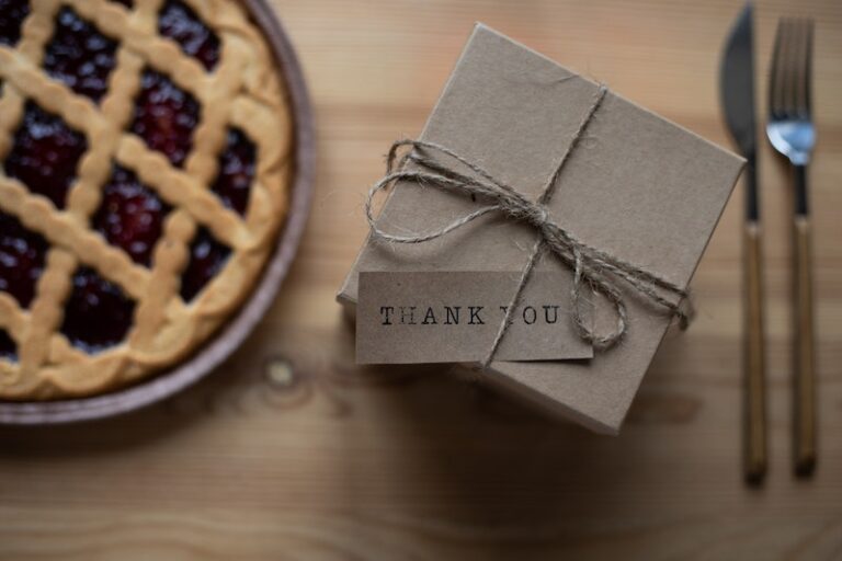 Cardboard present box with thank you postcard on table