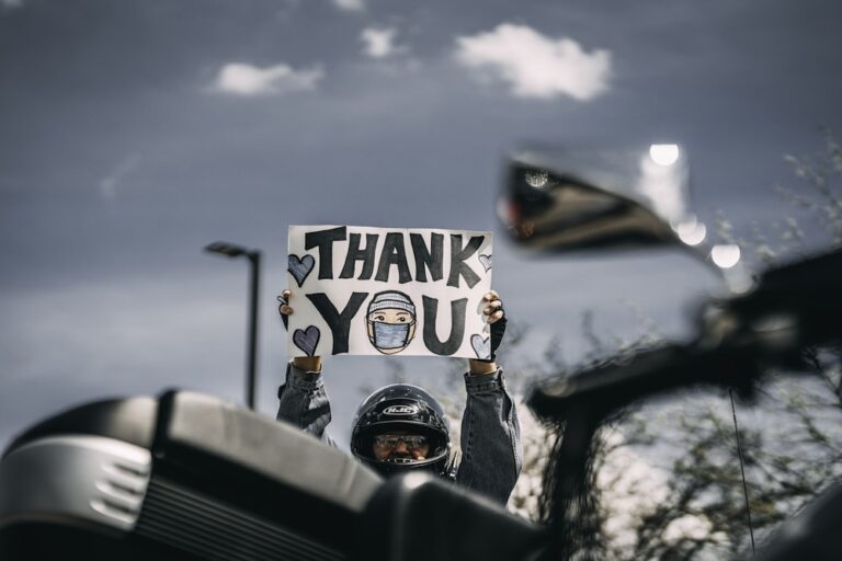 Man in black helmet holding Thank You sign