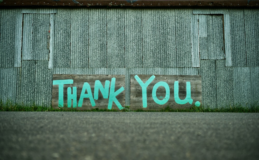 Metal sided building with Thank You painted on the side in blue paint