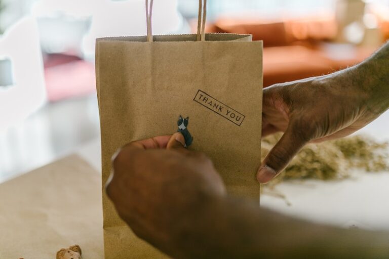 Person Putting a Dog Sticker on Paper Bag with Thank You Text