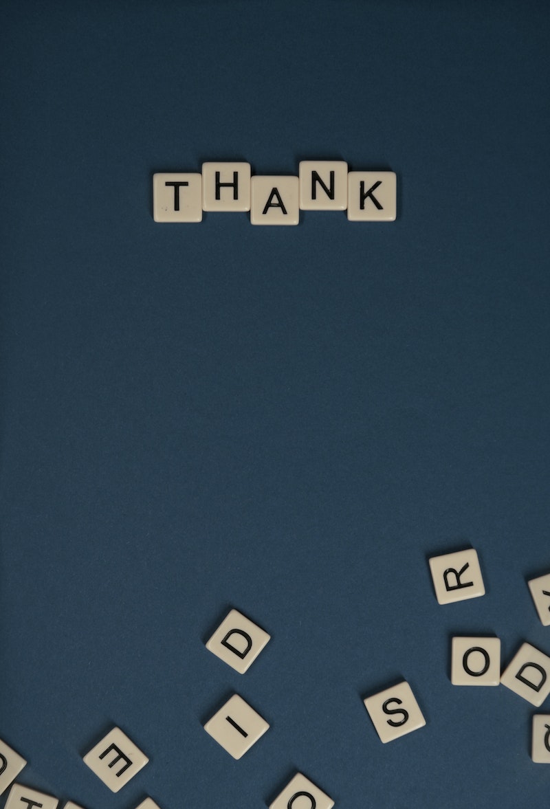 Photo of Thank Letter Tiles on Blue Surface