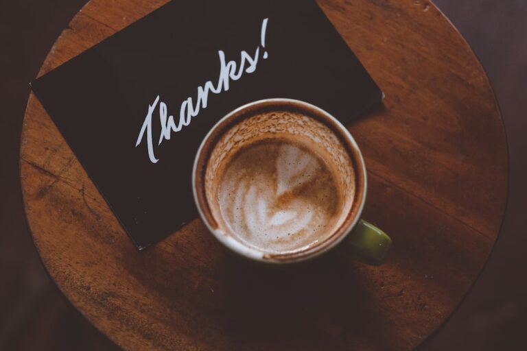 coffee latte in teacup on table and Thanks note